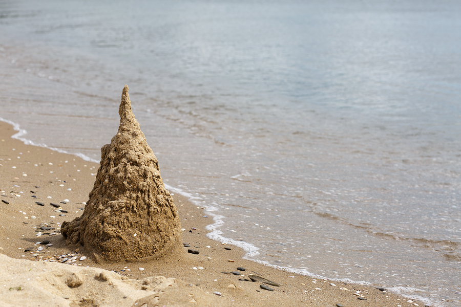 Sand castle destroyed by the surf. Black Sea coast. Space for text.